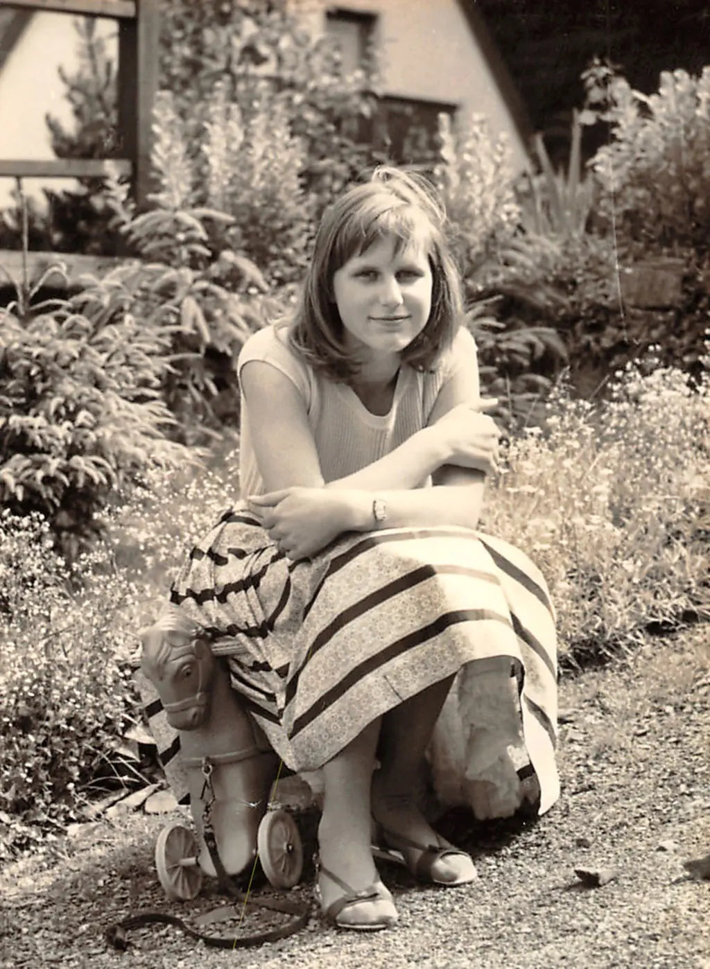 QUADRO-founder Doris Rüther in black and white sitting on a toy 