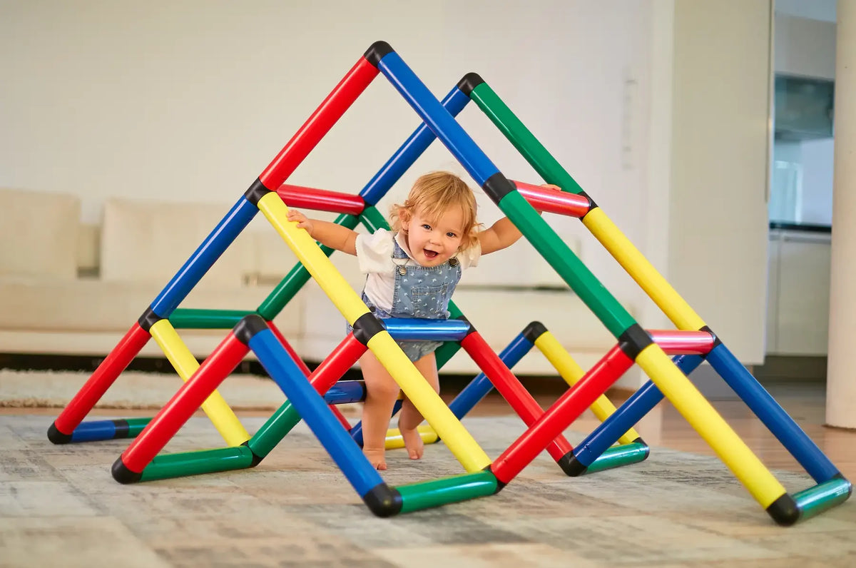 Toddler climbing through a low indoor QUADRO pyramid frame