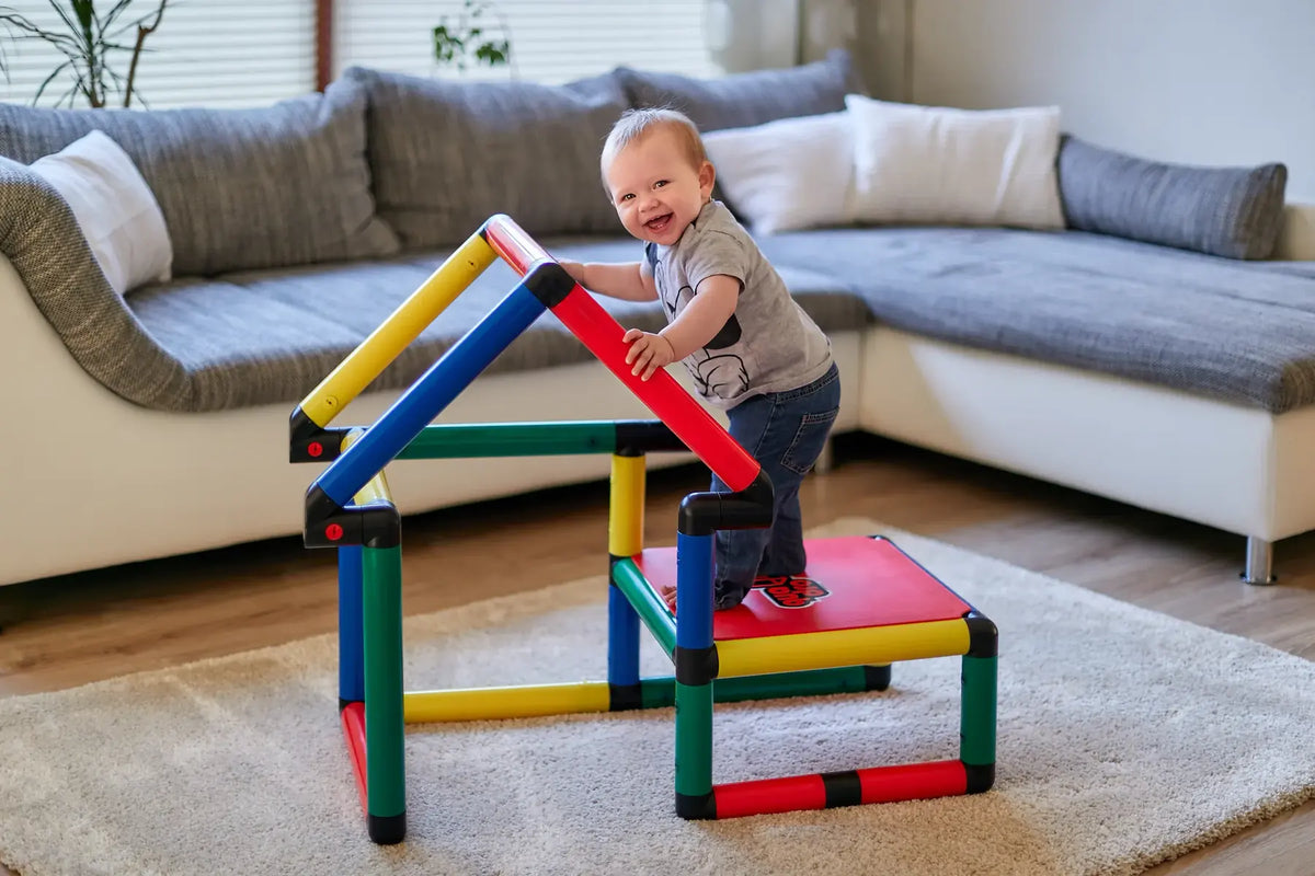 Toddler standing on a compact QUADRO step platform with triangular frame