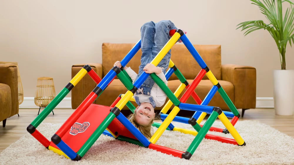 Child hanging upside down inside a large indoor QUADRO climbing pyramid