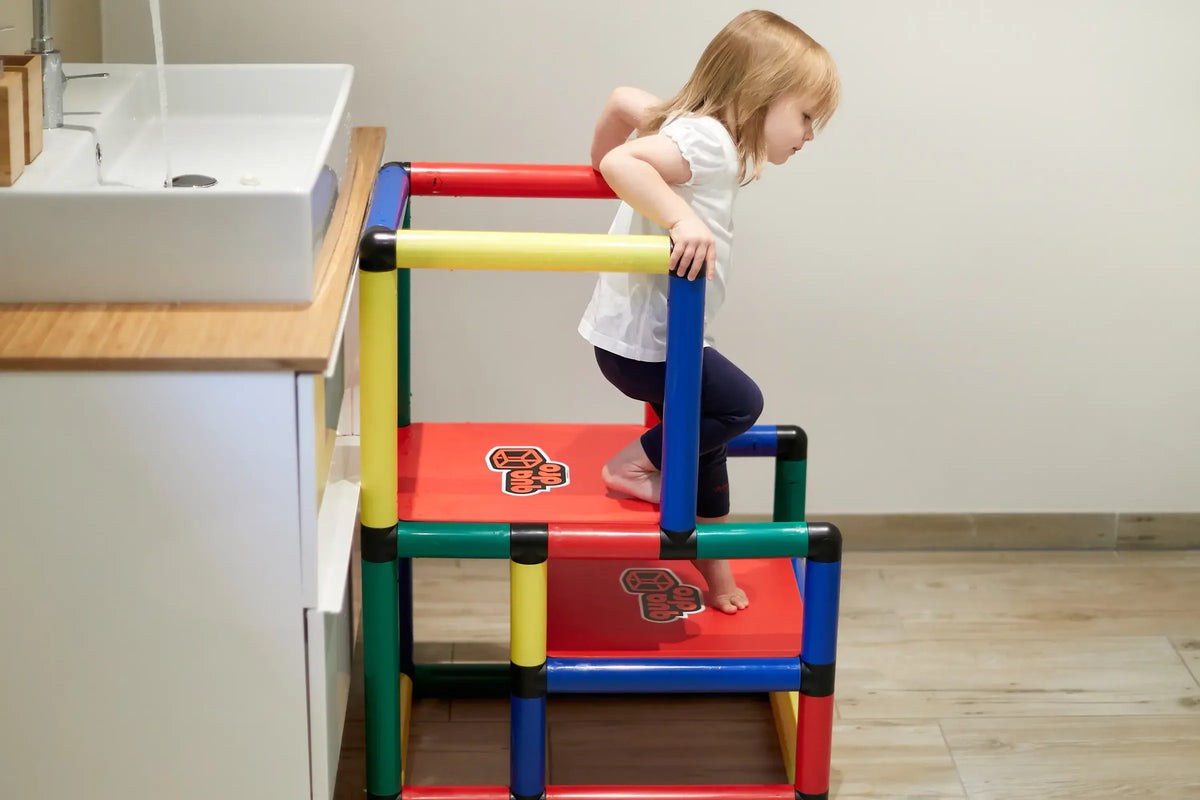 Child climbing down the stepped platforms of a QUADRO learning tower