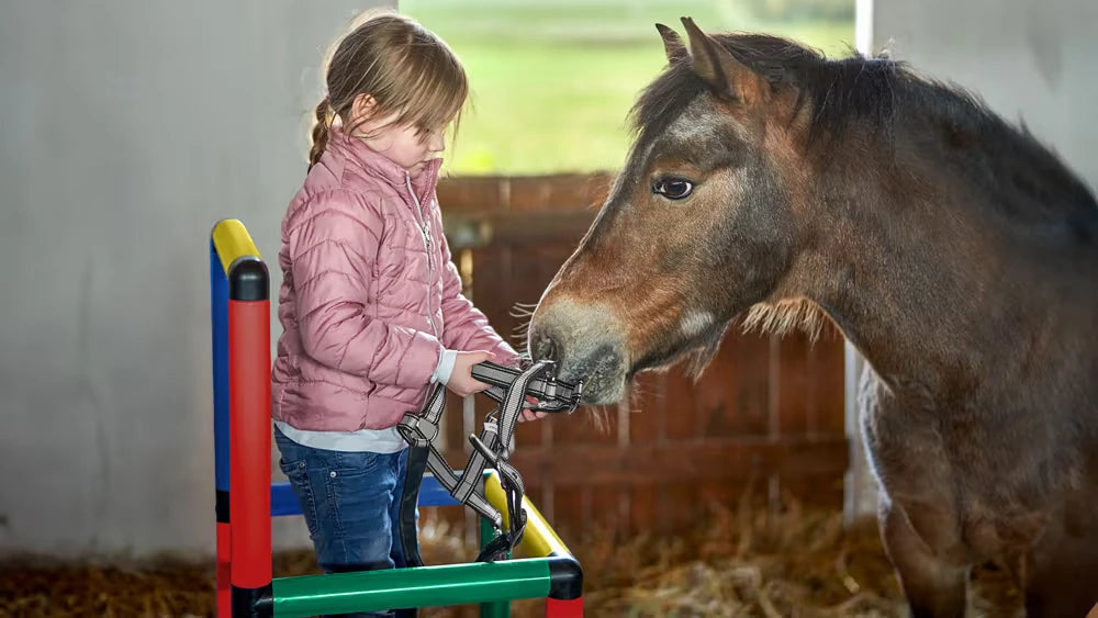 Child feeding a pony while standing behind the rail of a QUADRO platform