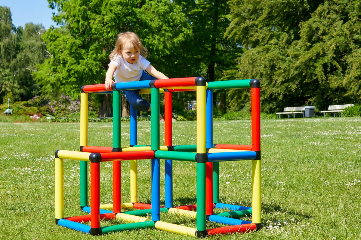 Children climbing across a wide tiered QUADRO cube structure on a lawn