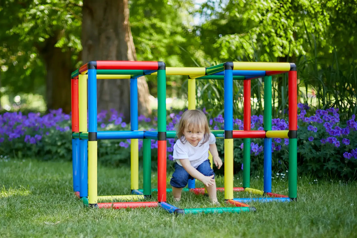 Child crawling through a wide QUADRO cube climbing structure in a garden