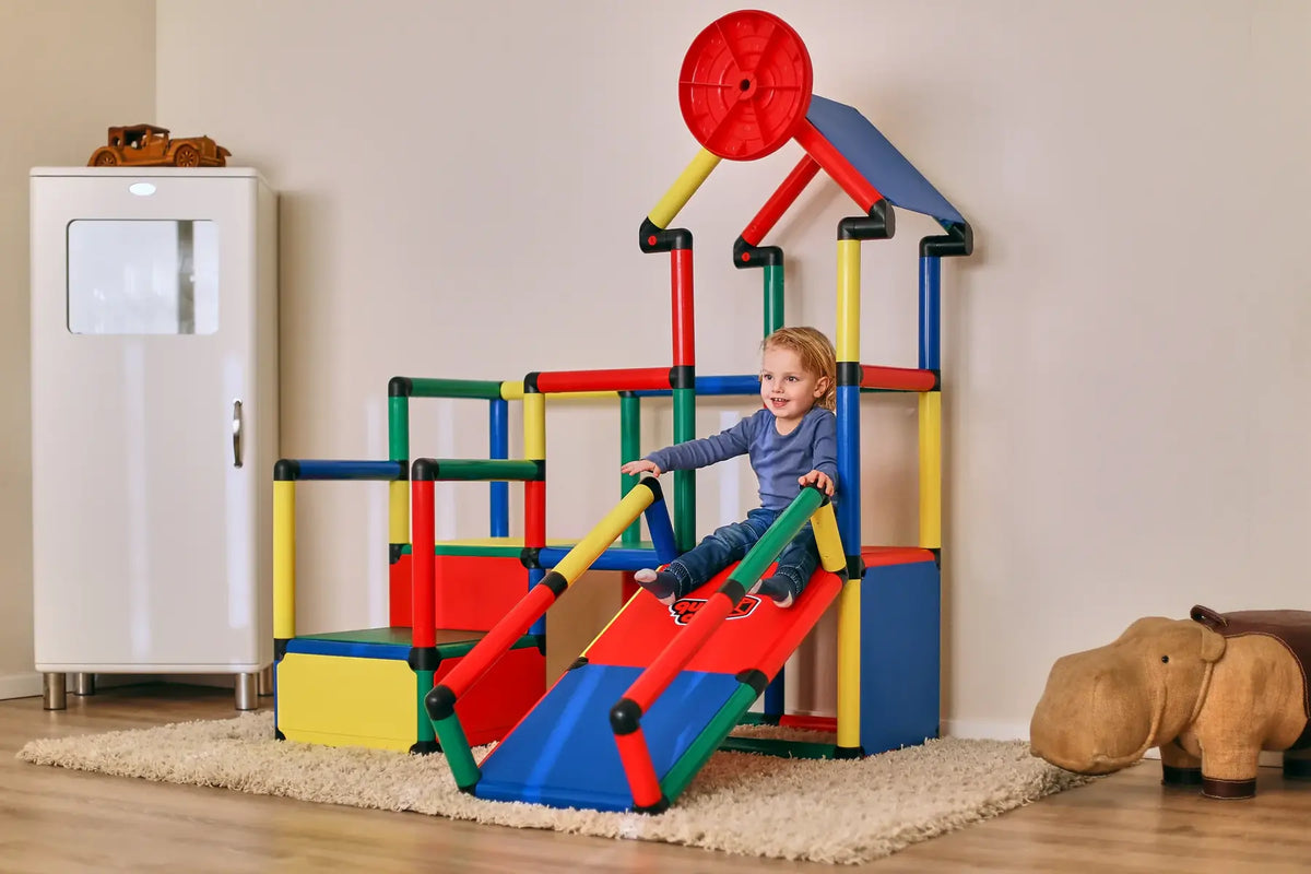 Child sliding down the ramp of an indoor QUADRO Evolution play structure
