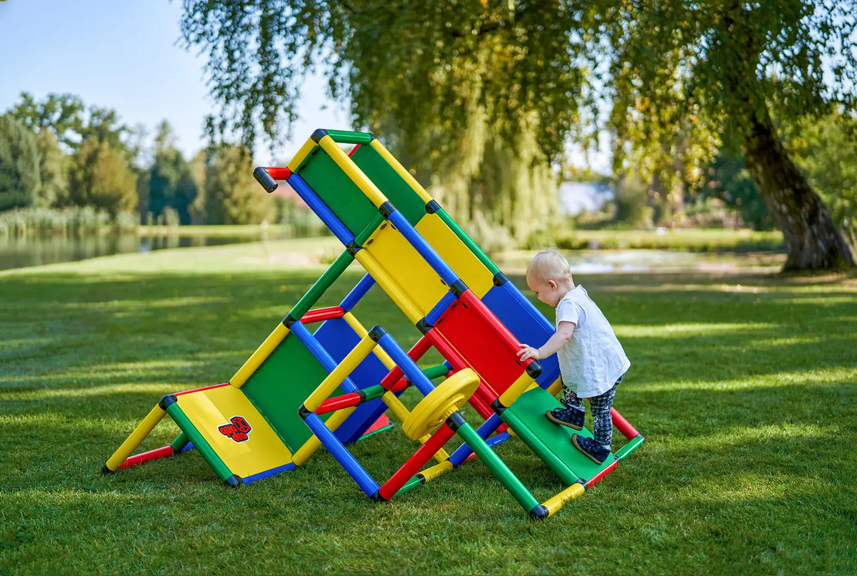 Toddler climbing an angled QUADRO Evolution frame outdoors