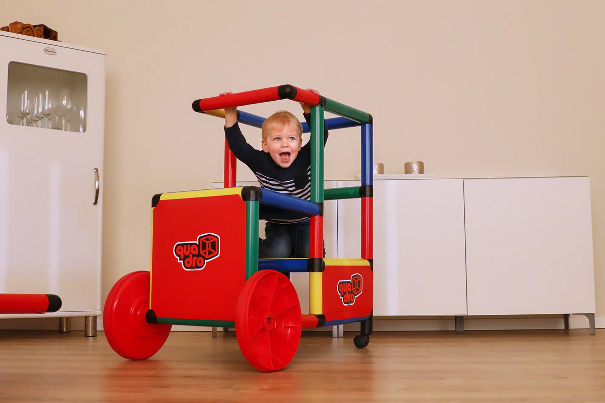 Child inside a colourful QUADRO Evolution train with red wheels