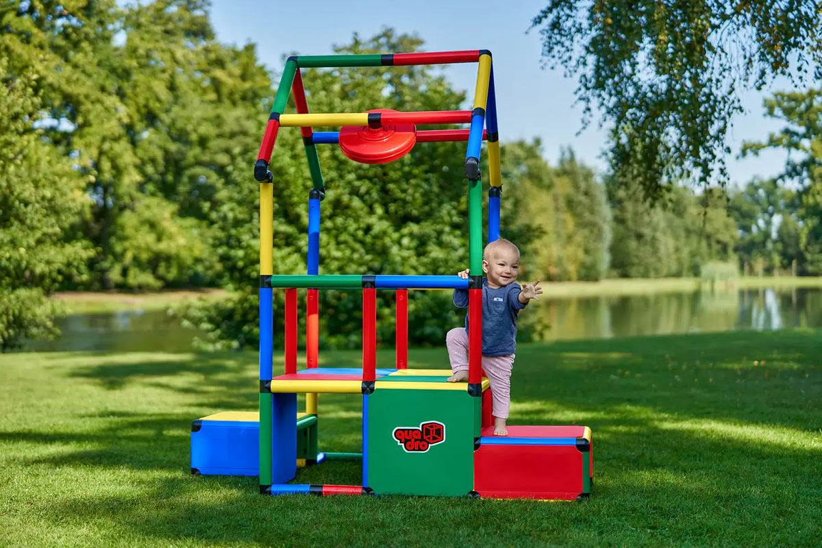 Toddler beside an outdoor QUADRO Evolution play stand with counter