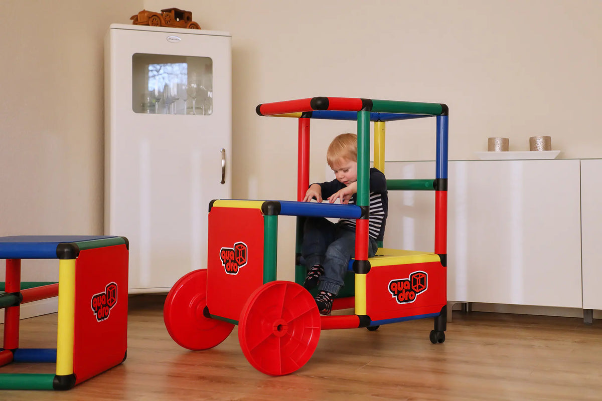 Child seated in a QUADRO Evolution train beside a matching carriage