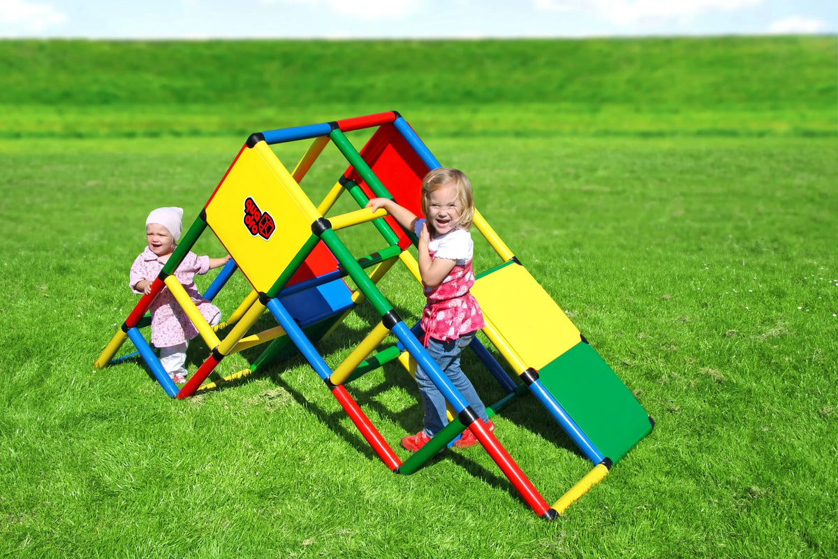 Two children climbing a low angular QUADRO Universal pyramid outdoors