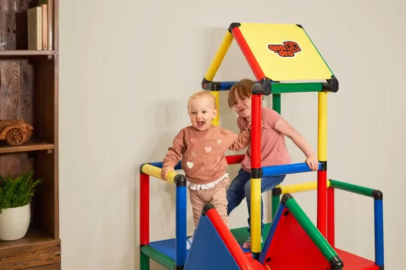 Two toddlers playing on a roofed QUADRO climbing tower with ramp